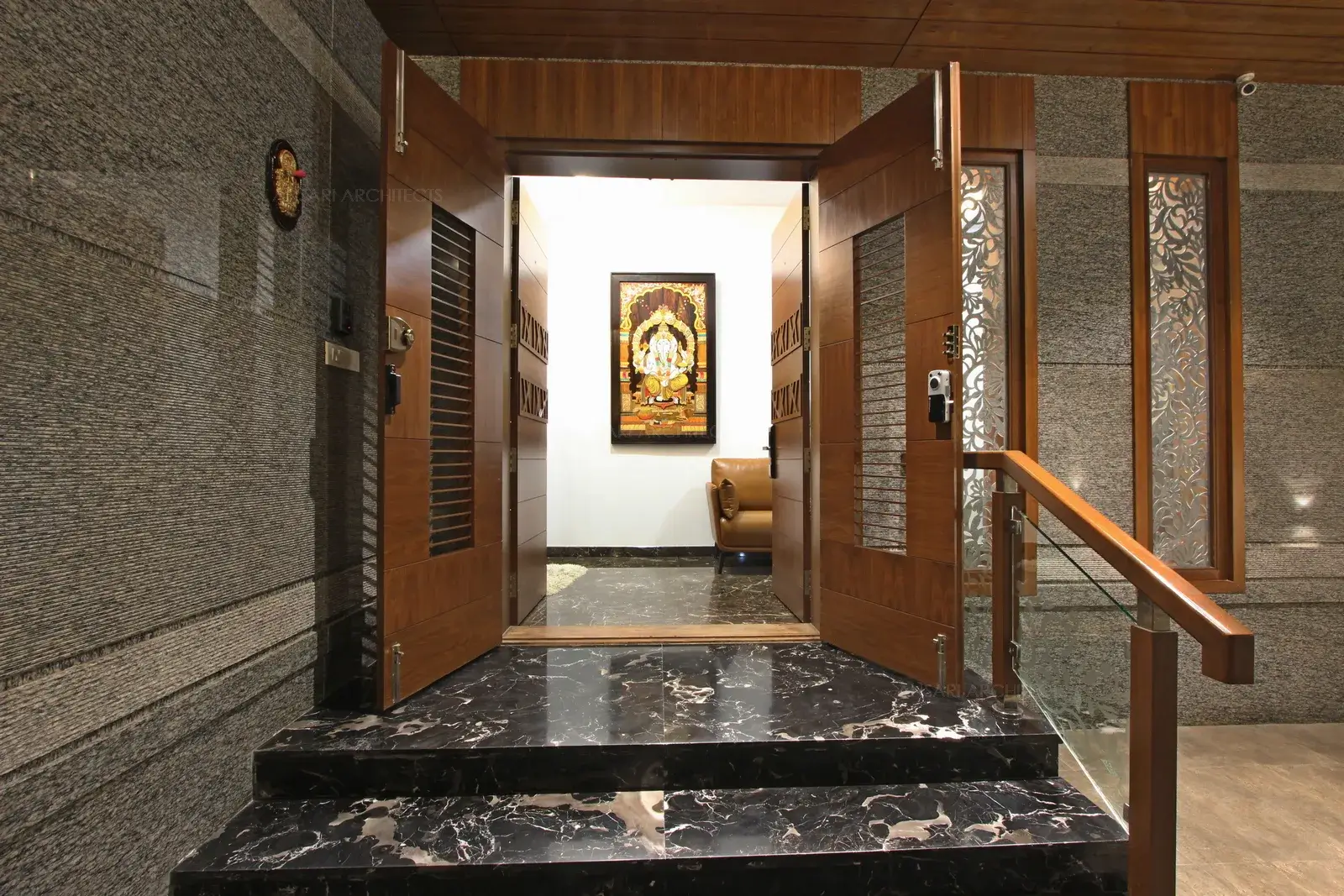 The wooden doors with antique finishes punctuate ethnic accents with glass adding punch to modern embellishment opening to the foyer area.