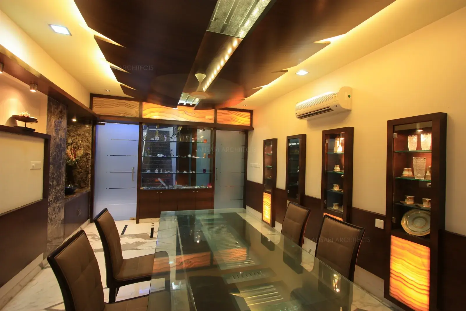 Two way display unit with clear glass has been designed as partition in the entrance which acts as a focal point in the ding area.