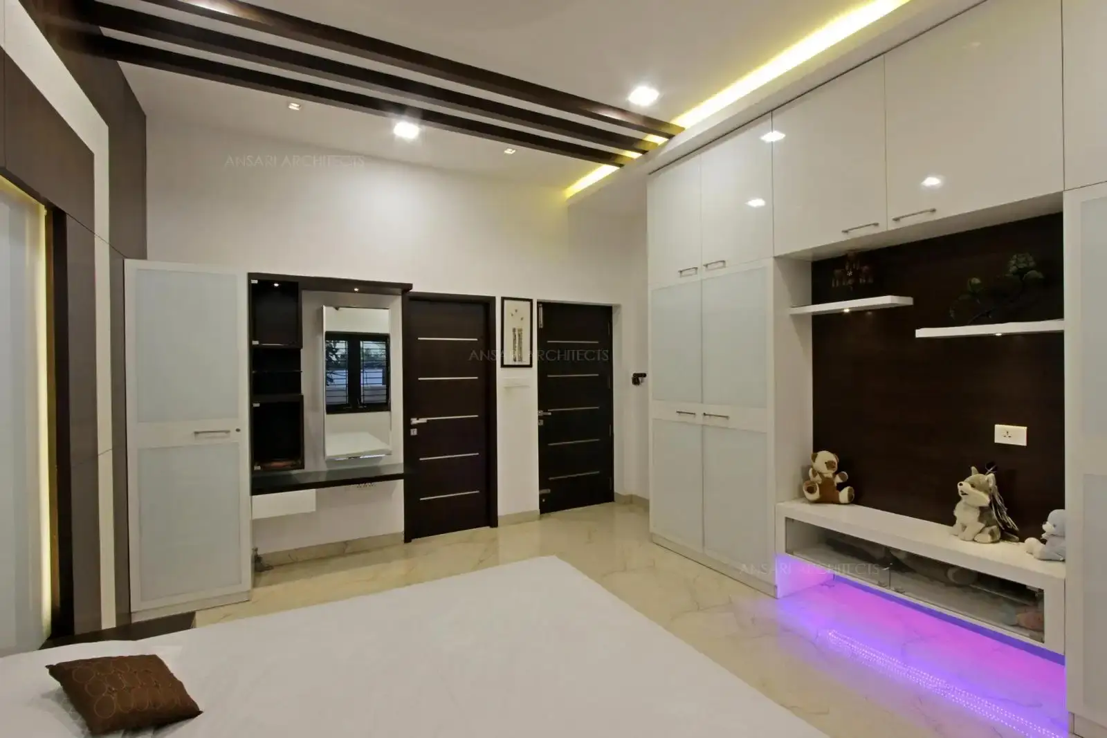 The entire wall is divided to form an alcove like feature wall with custom decor, panelling as an backdrop with lights taht provide contrast here. Vanity unit with mirror in a sleek design.