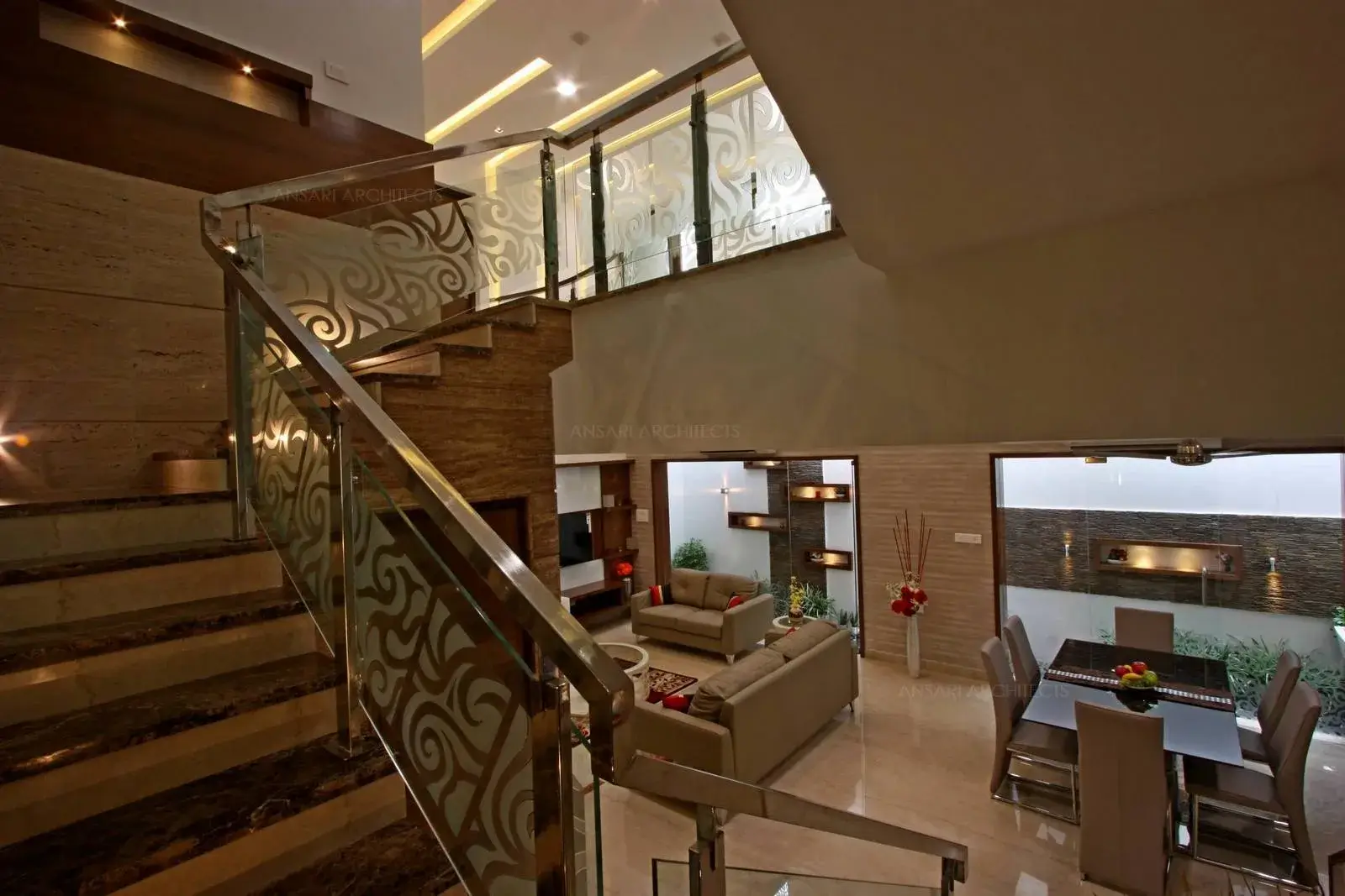 The staircase space with wooden and glass handrail leading towards the next floor.