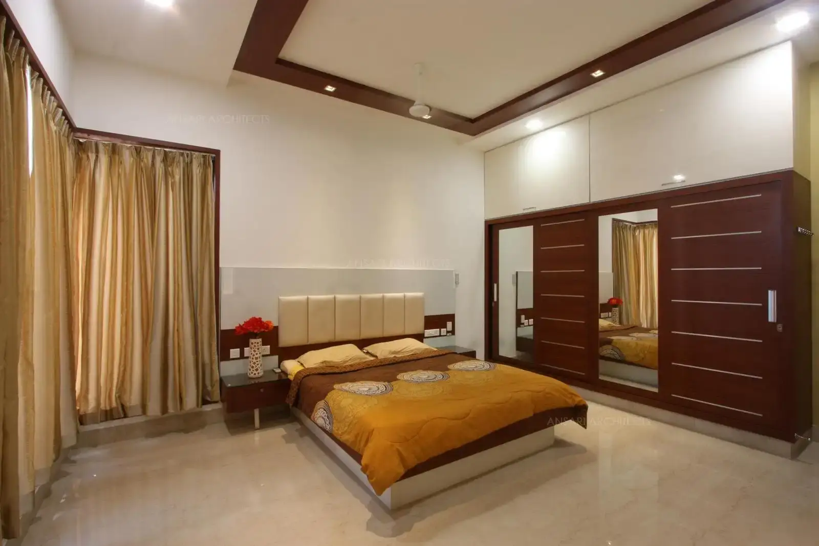 Wardrobe mirror adds an attractive finish, complementing the dark tone of wood creates a contrast. The overhead cabinets stramlined look appetizes the space.