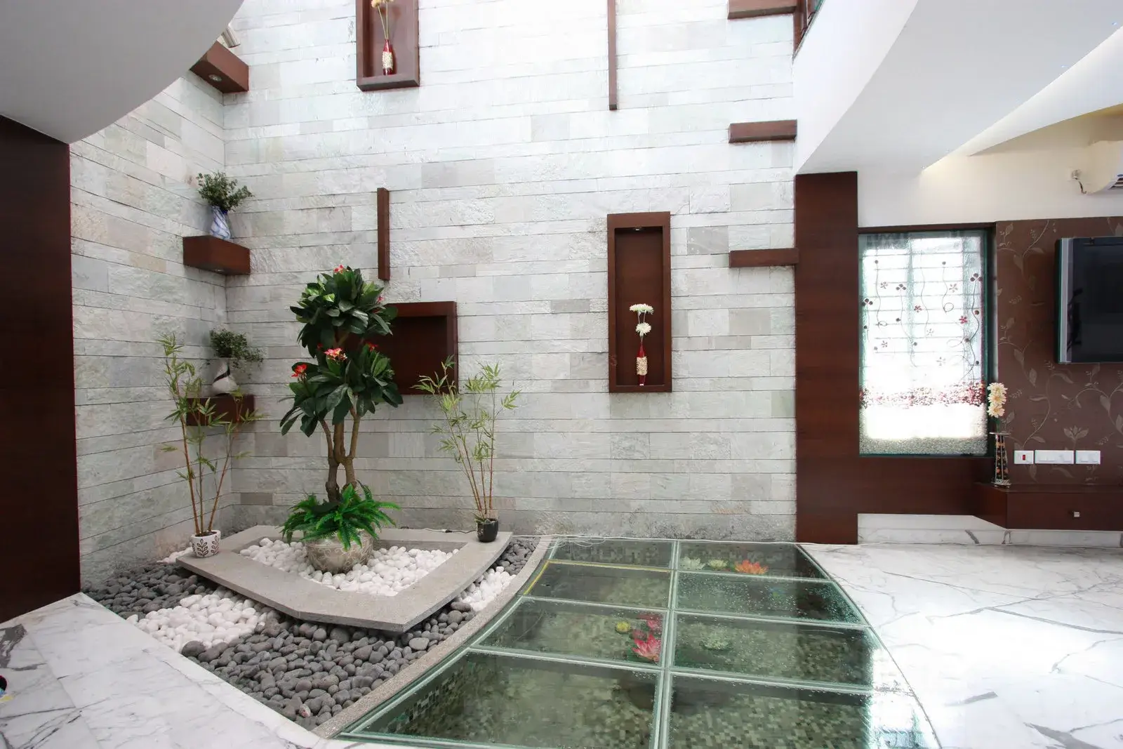 Courtyard area in the living room has been designed with floor aquarium covered with toughened glass.